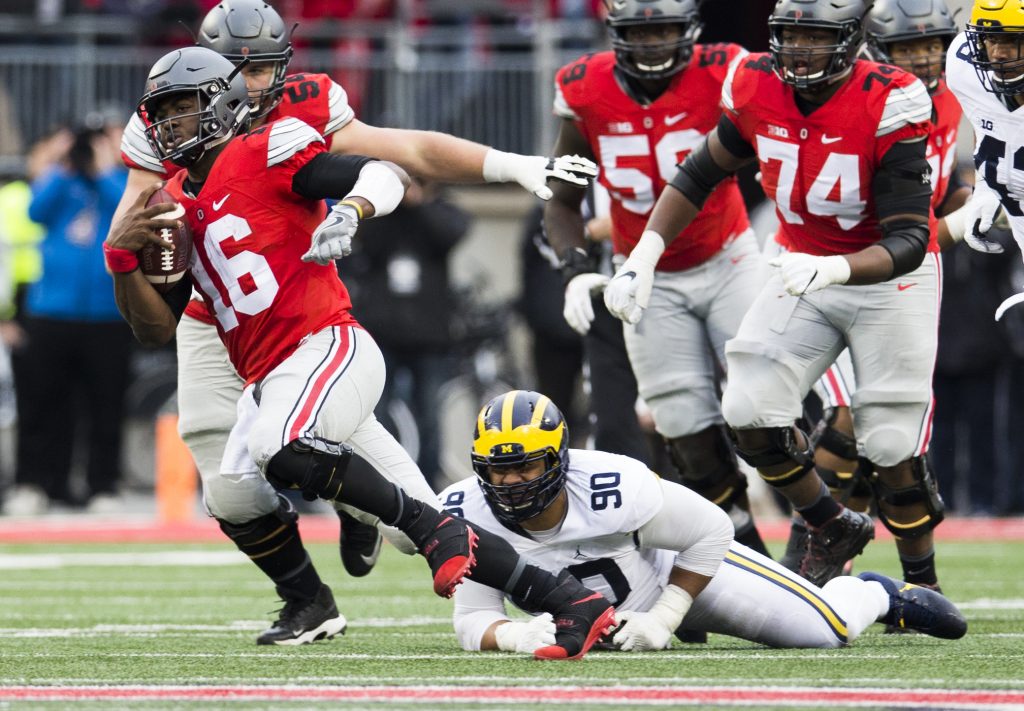 Nov 26, 2016; Columbus, OH, USA; Ohio State Buckeyes quarterback J.T. Barrett (16) escapes a tackle attempted by Michigan Wolverines defensive tackle Bryan Mone (90) in the third quarter at Ohio Stadium. Ohio State won the game 30-27 in double overtime. PHOTO: Greg Bartram-USA TODAY Sports